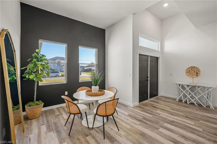 Dining room with a high ceiling and light hardwood / wood-style flooring