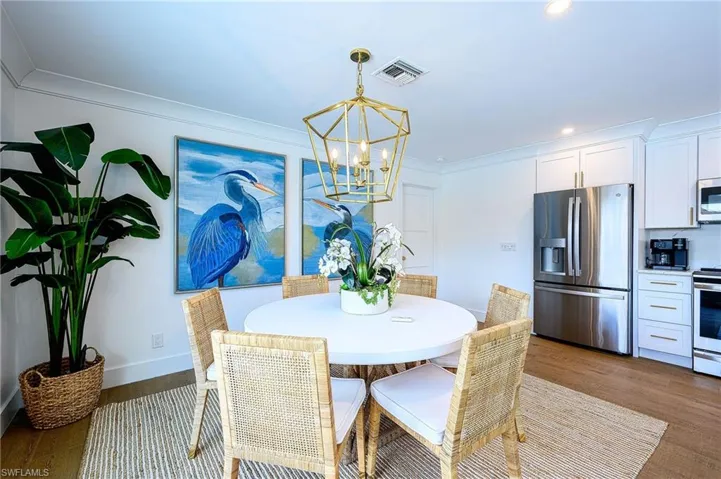 Dining area featuring an inviting chandelier, hardwood / wood-style flooring, and crown molding