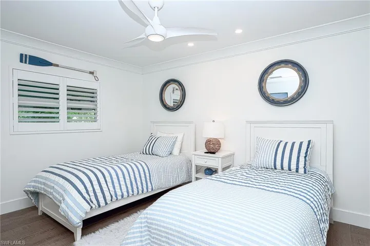 Bedroom featuring ornamental molding, dark wood-type flooring, and ceiling fan