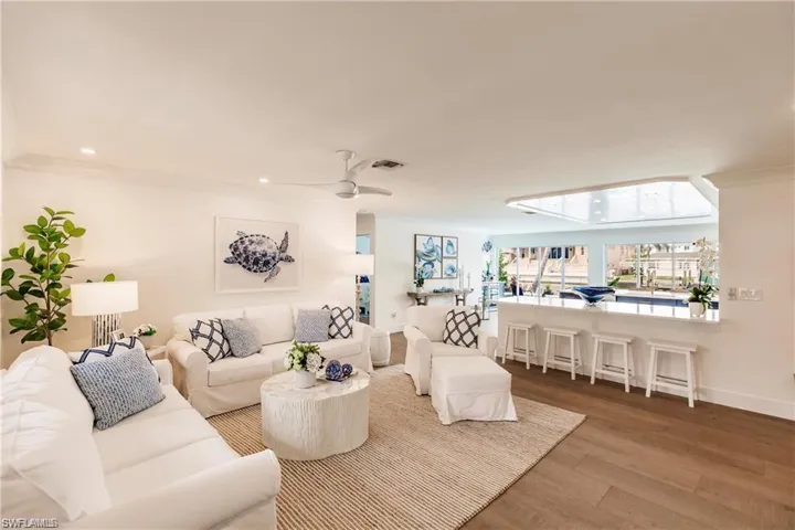 Living room with ceiling fan, hardwood / wood-style flooring, and crown molding