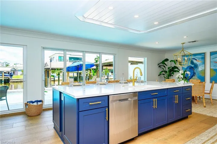 Kitchen with blue cabinets, dishwasher, light wood-type flooring, and sink