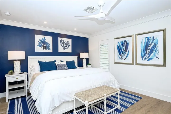 Bedroom with ornamental molding, ceiling fan, and hardwood / wood-style flooring