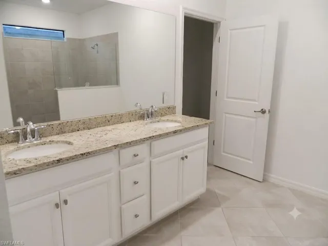 Dual vanity with light-colored speckled countertop, undermount sinks, and chrome faucets