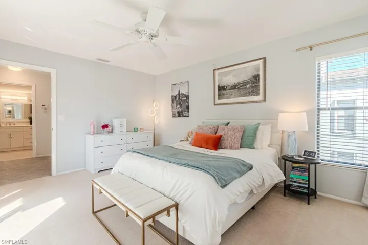 Bedroom featuring ceiling fan, sink, and light carpet