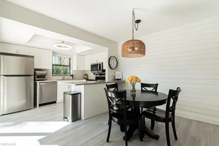 Dining area featuring wood walls, sink, and light wood-type flooring
