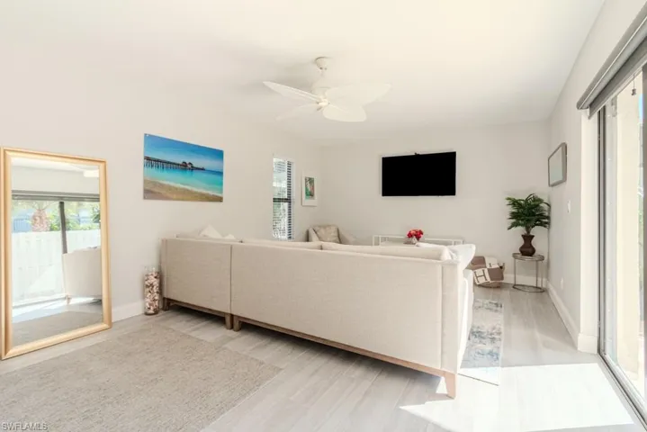 Living room with ceiling fan, a healthy amount of sunlight, and light wood-type flooring