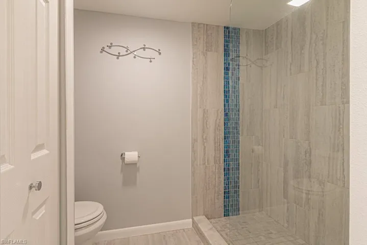 Bathroom featuring toilet and tiled shower