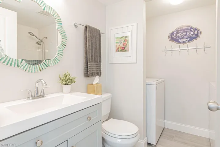 Bathroom featuring vanity, washer / clothes dryer, toilet, and hardwood / wood-style flooring