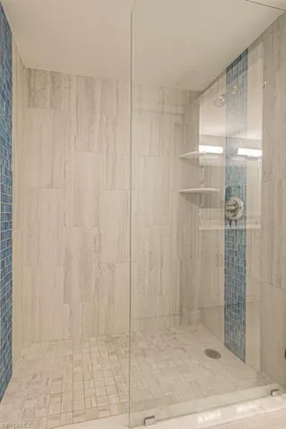 Bathroom featuring a tile shower and tile walls