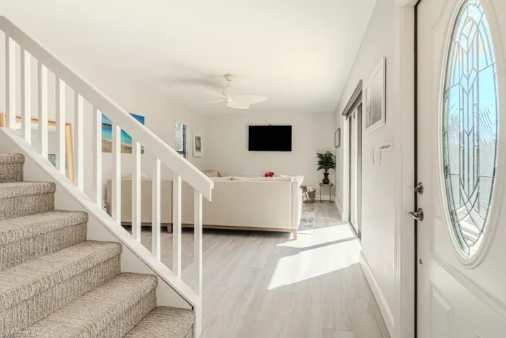 Foyer entrance with ceiling fan and light wood-type flooring