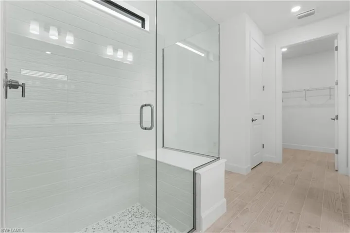 view of primary bathroom leading into spacious closet