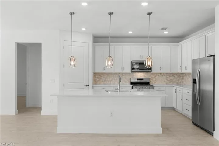 quartz countertops, tile backsplash stainless steel appliances and pantry