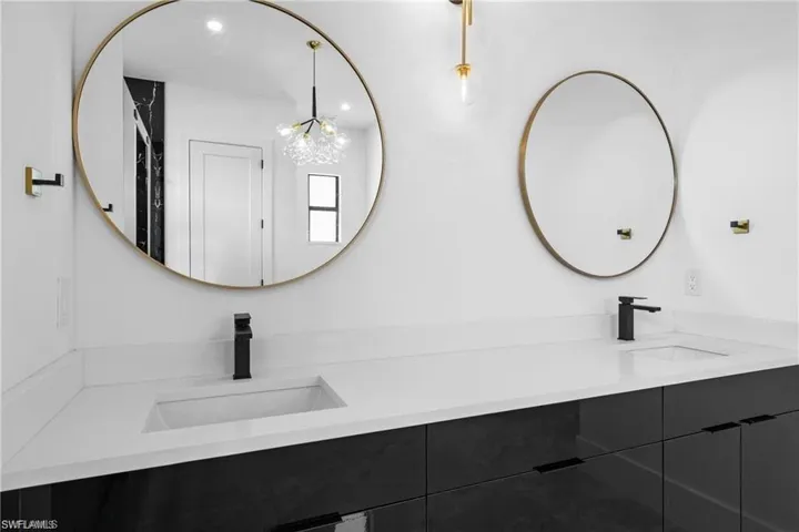 Bathroom with a notable chandelier and dual vanity