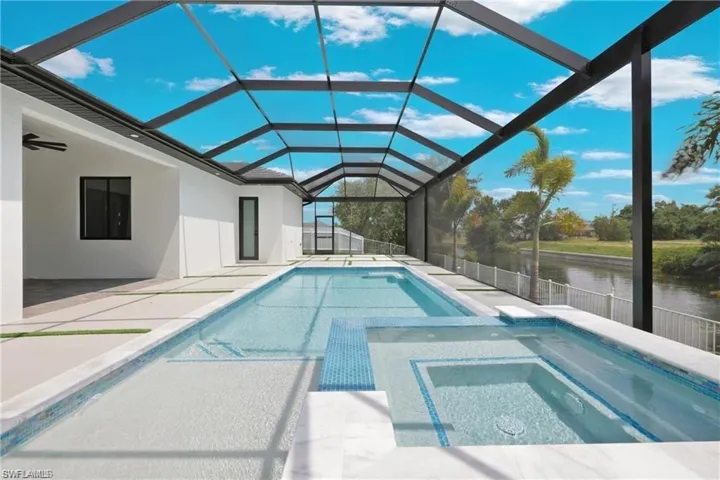 View of swimming pool featuring a patio area, glass enclosure, ceiling fan, and a water view