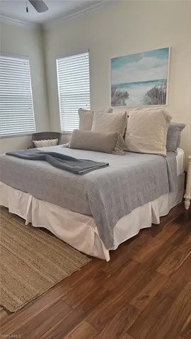Bedroom featuring wood finished floors and crown molding