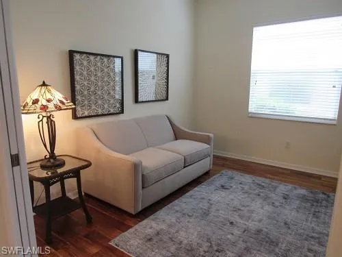 Sitting room with dark wood-style floors and baseboards