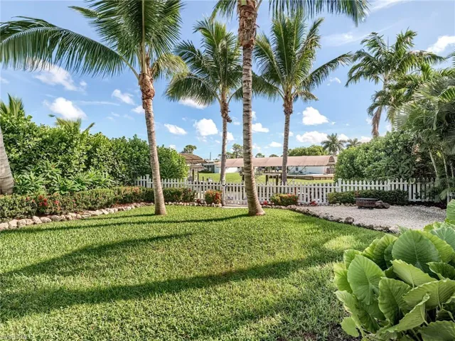 A deep backyard with an oversized pavered deck, tiki hut, fire pit area and fenced off dock area to keep your pets dry!