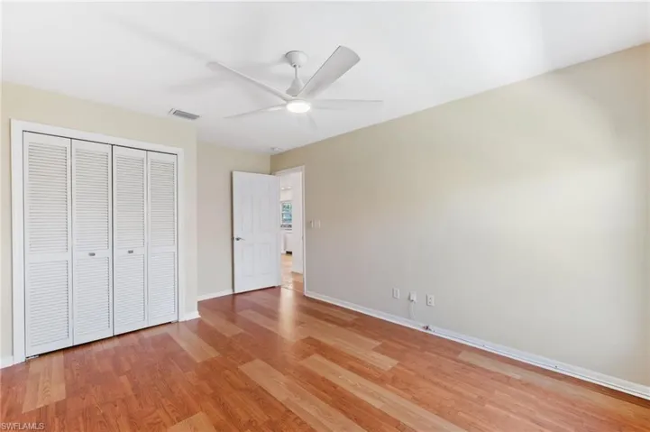 Unfurnished bedroom with light wood-type flooring, visible vents, a closet, baseboards, and ceiling fan