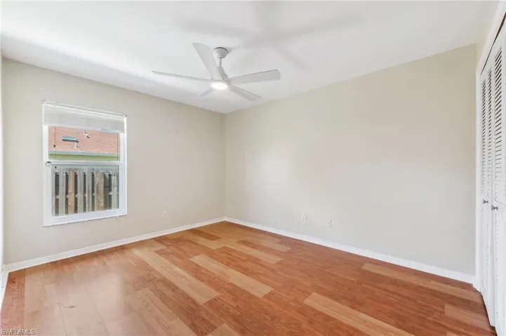 Empty room with light wood-type flooring, baseboards, and ceiling fan