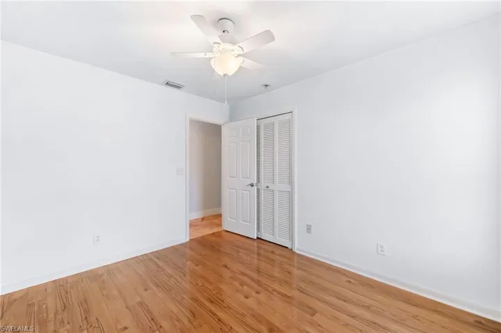 Spare room featuring visible vents, light wood-style flooring, baseboards, and a ceiling fan
