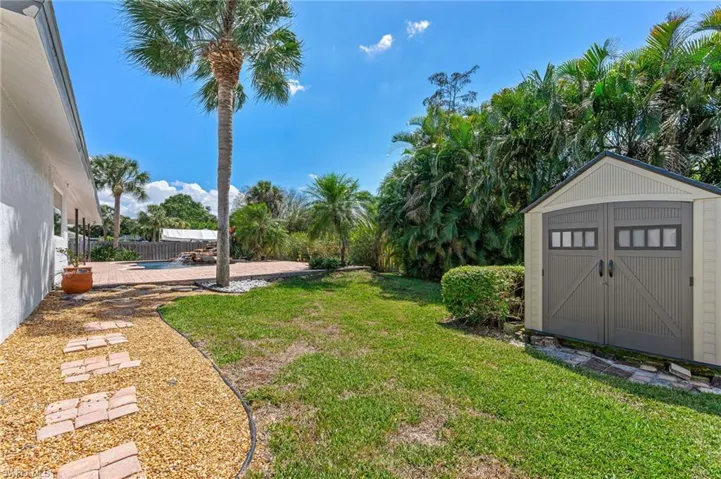 View of yard featuring an outbuilding, a patio area, a storage shed, and a fenced backyard