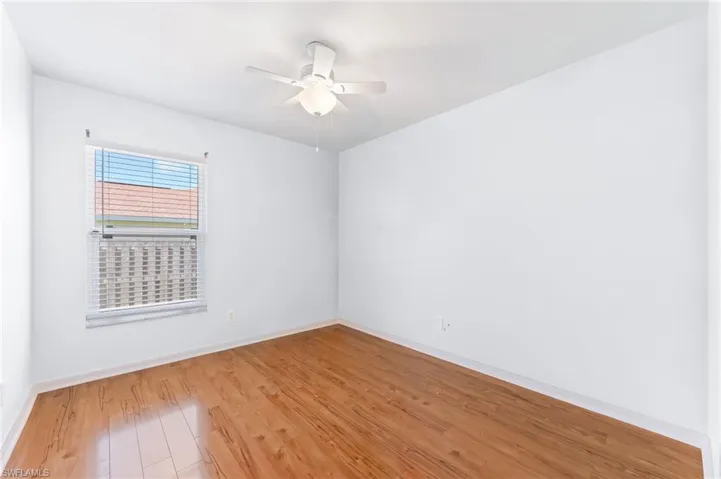Unfurnished room featuring ceiling fan, light wood-type flooring, and baseboards