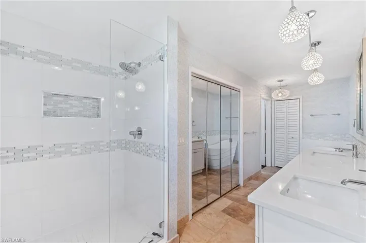 Full bath with a sink, a stall shower, and double vanity