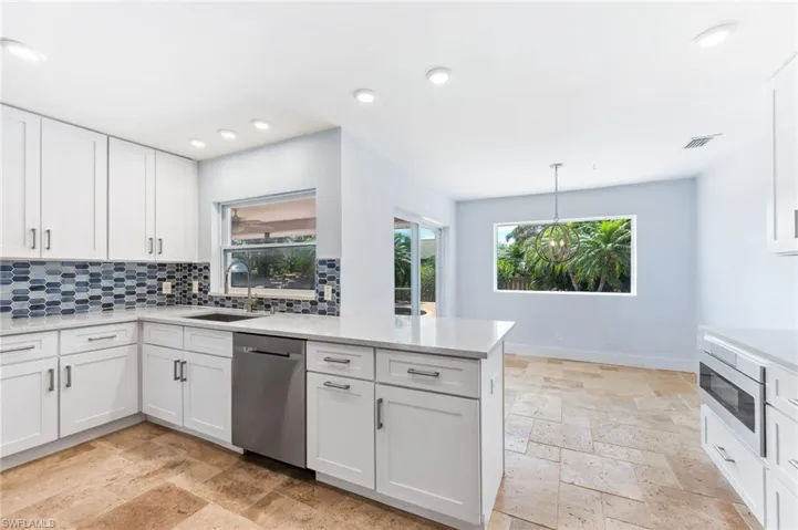 Kitchen showing breakfast nook and impact resistant picture window looking to backyard