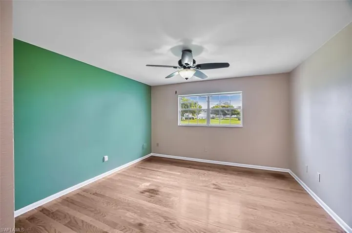 Unfurnished room with light wood finished floors and ceiling fan