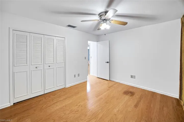 Unfurnished bedroom with light wood-style floors, ceiling fan, and a closet
