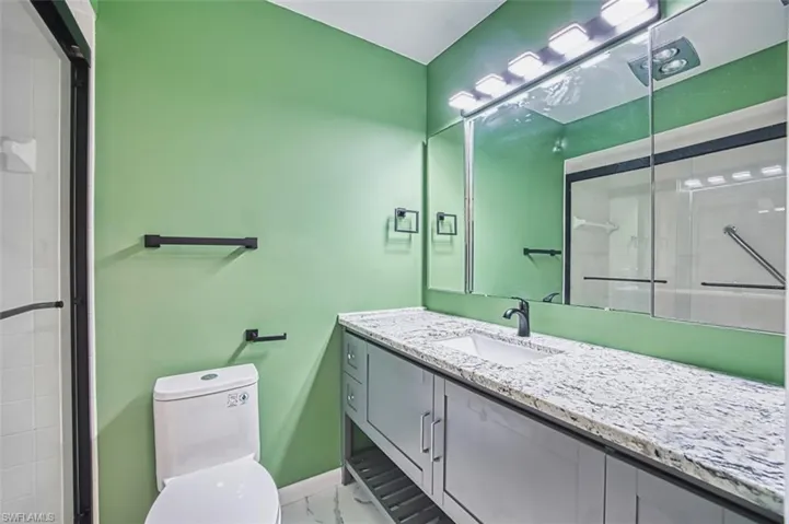 Bathroom with a stall shower, vanity, and light marble finish flooring