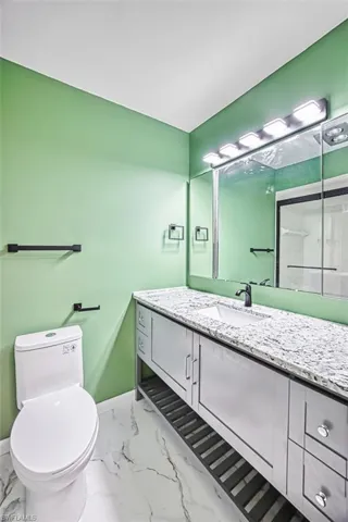 Bathroom featuring light marble finish flooring and vanity