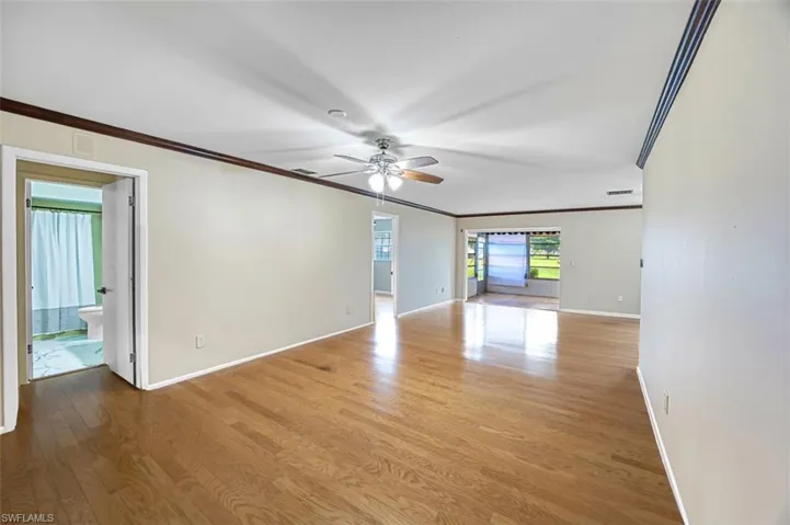 Unfurnished room featuring crown molding, light wood-style flooring, and ceiling fan