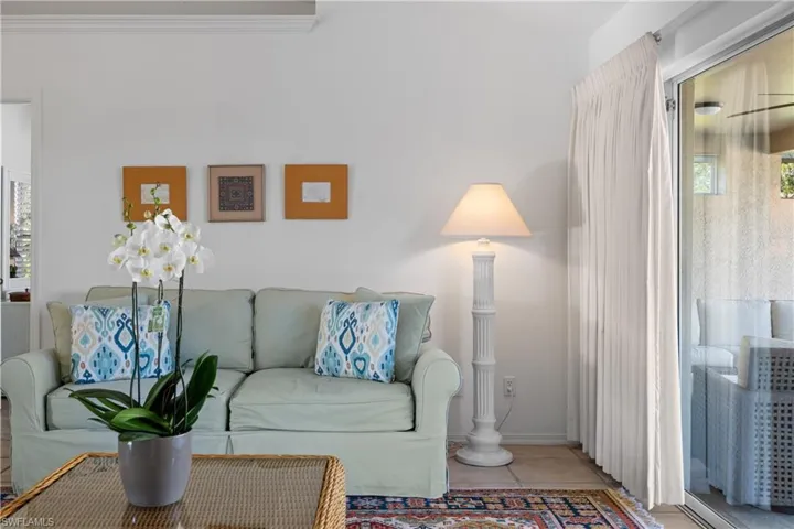 Living room with tile patterned flooring and ornamental molding