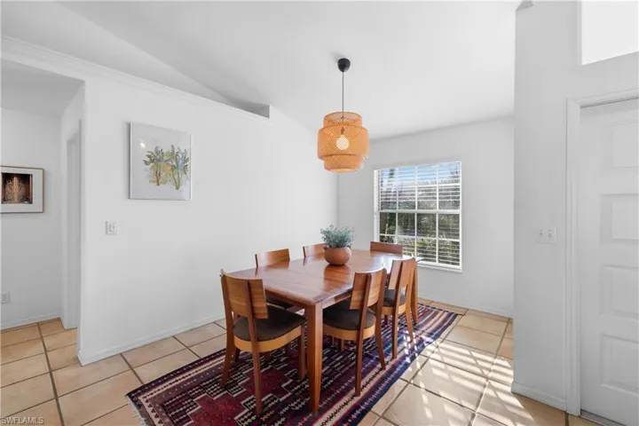 Dining space featuring vaulted ceiling and light tile patterned floors