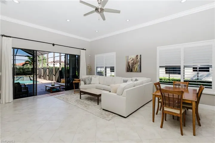 Living room with ornamental molding, a sunroom, recessed lighting, ceiling fan, and light tile patterned floors