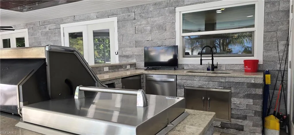 Bar area with a sink and stainless steel dishwasher