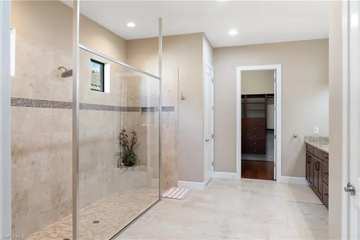 Spacious bathroom featuring a large walk-in shower with tile surround, glass enclosure, and a built-in niche