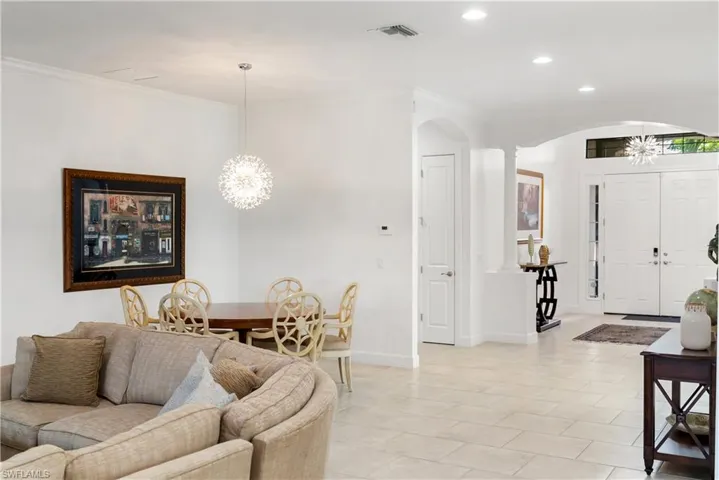 Expansive tiled flooring, recessed lighting, and a decorative pendant light fixture