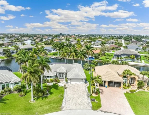 Pie shaped lot adorned with palm trees and lush landscaping