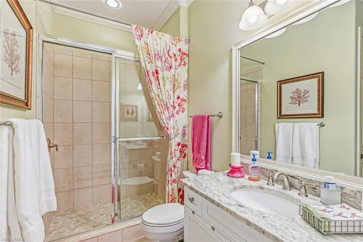 Full bathroom with vanity, a stall shower, and crown molding
