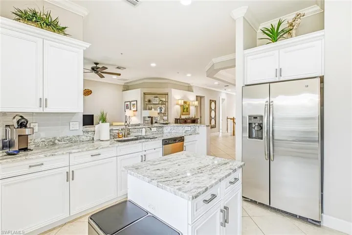 Kitchen featuring light tile patterned floors, stainless steel appliances, crown molding, white cabinets, and recessed lighting