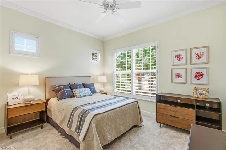 Bedroom featuring crown molding, a ceiling fan, and light carpet