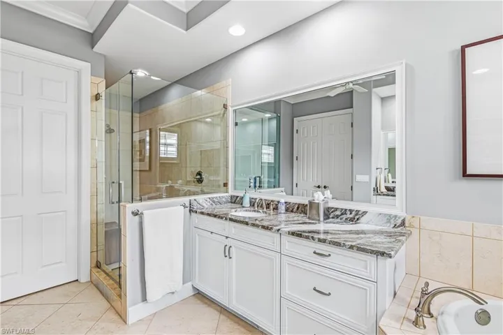 Full bath with vanity, a stall shower, tiled tub, light tile patterned flooring, and crown molding