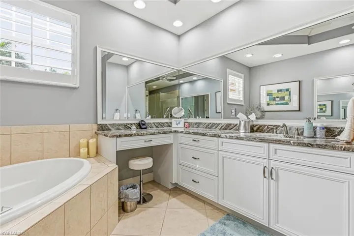 Bathroom featuring a bath, vanity, and light tile patterned floors