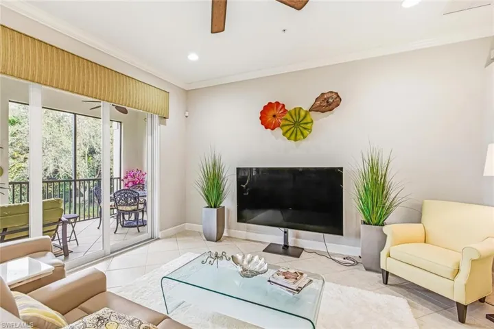 Tiled living room featuring ceiling fan, recessed lighting, and ornamental molding