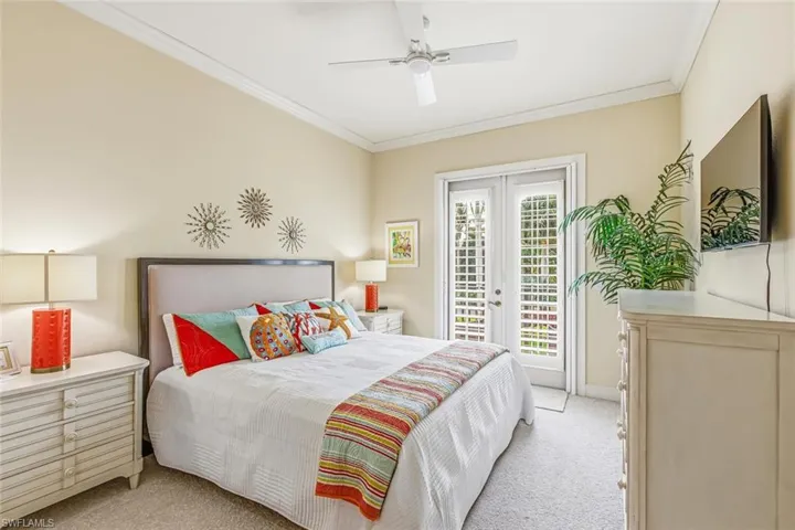 Bedroom featuring light carpet, french doors, access to outside, crown molding, and a ceiling fan