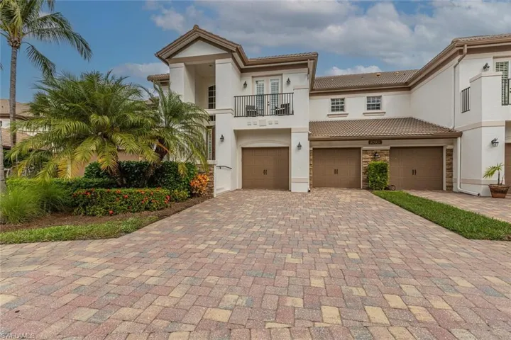 Mediterranean / spanish-style house featuring a balcony, decorative driveway, stucco siding, a garage, and french doors