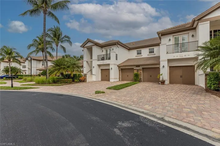 Mediterranean / spanish-style house featuring a balcony, stucco siding, a garage, a residential view, and driveway