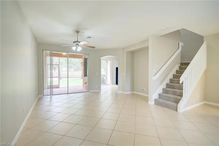 Tiled spare room featuring ceiling fan